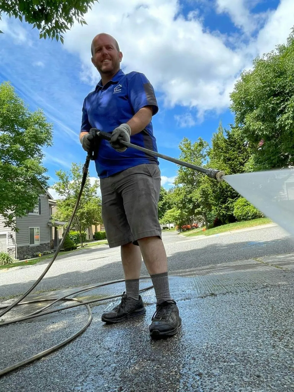 Technician surface-cleaning a residential driveway