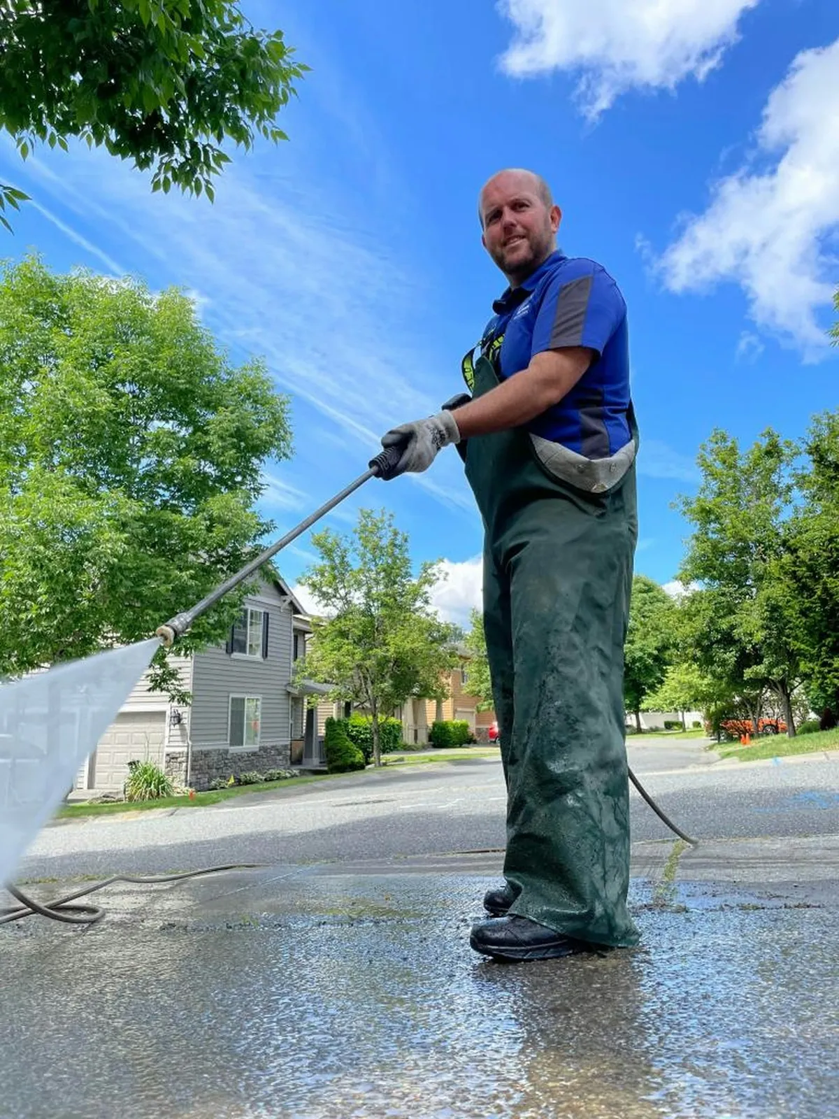 Technician washing a driveway