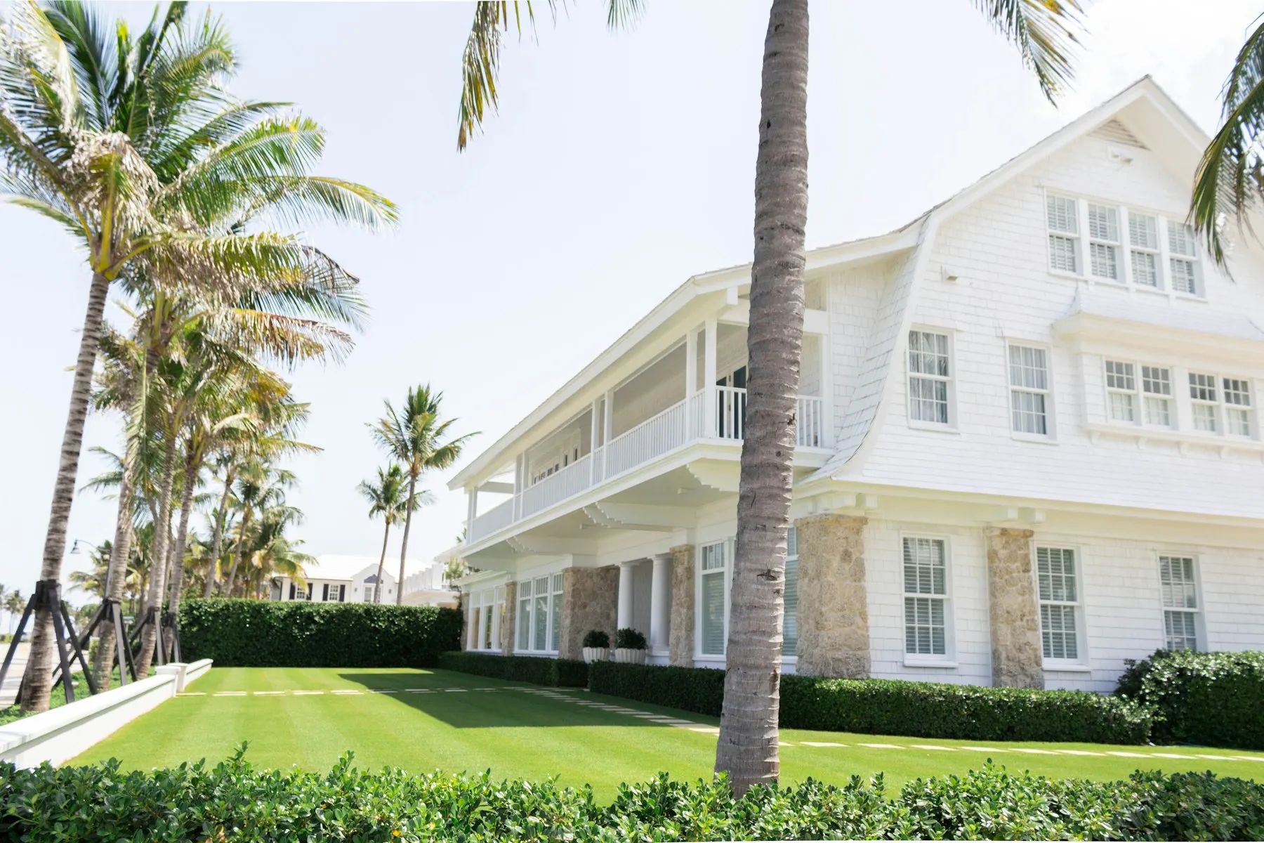 White two-story Florida home with palm trees after a soft wash