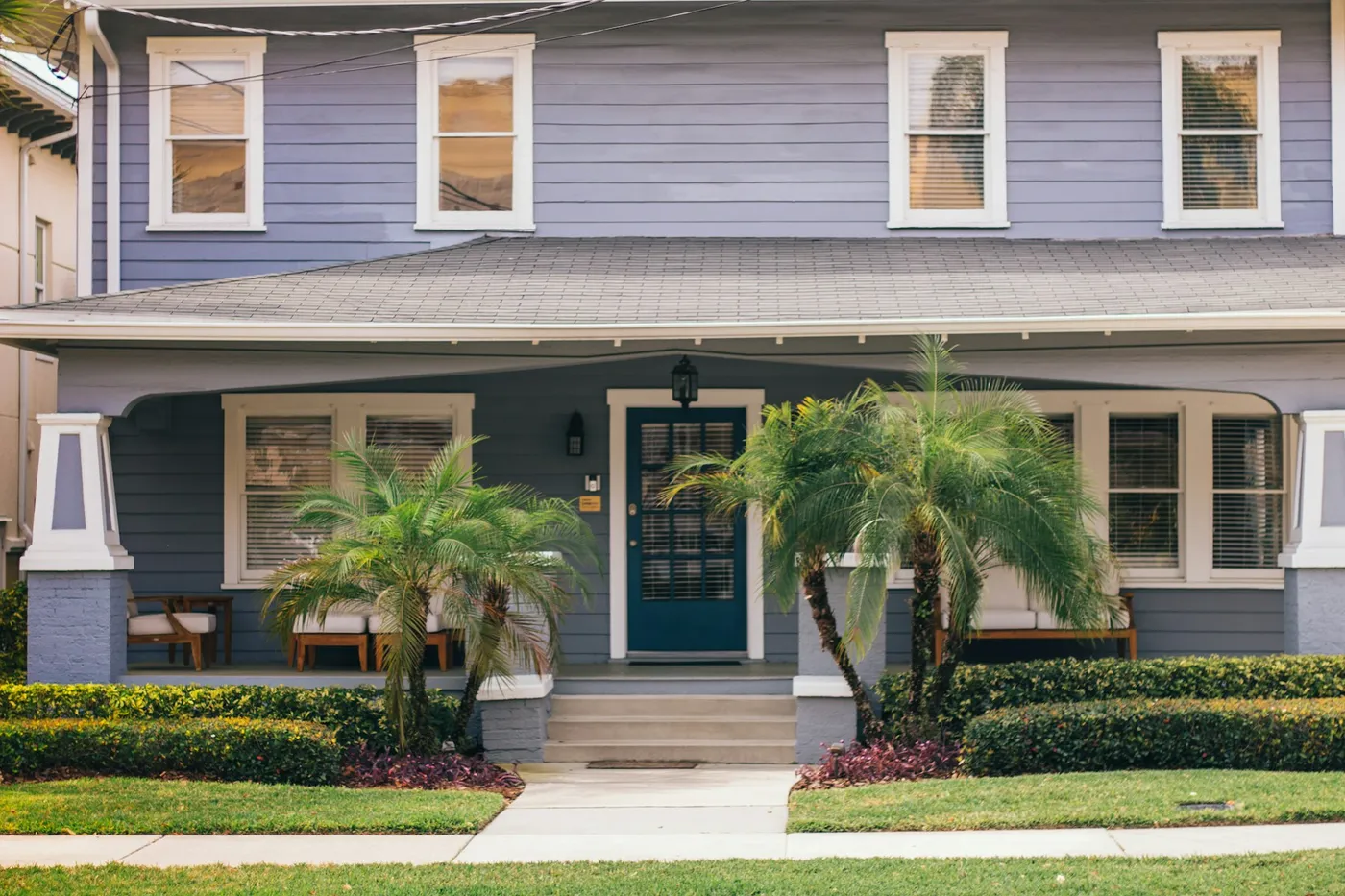 Craftsman-style home with a clean porch and palms